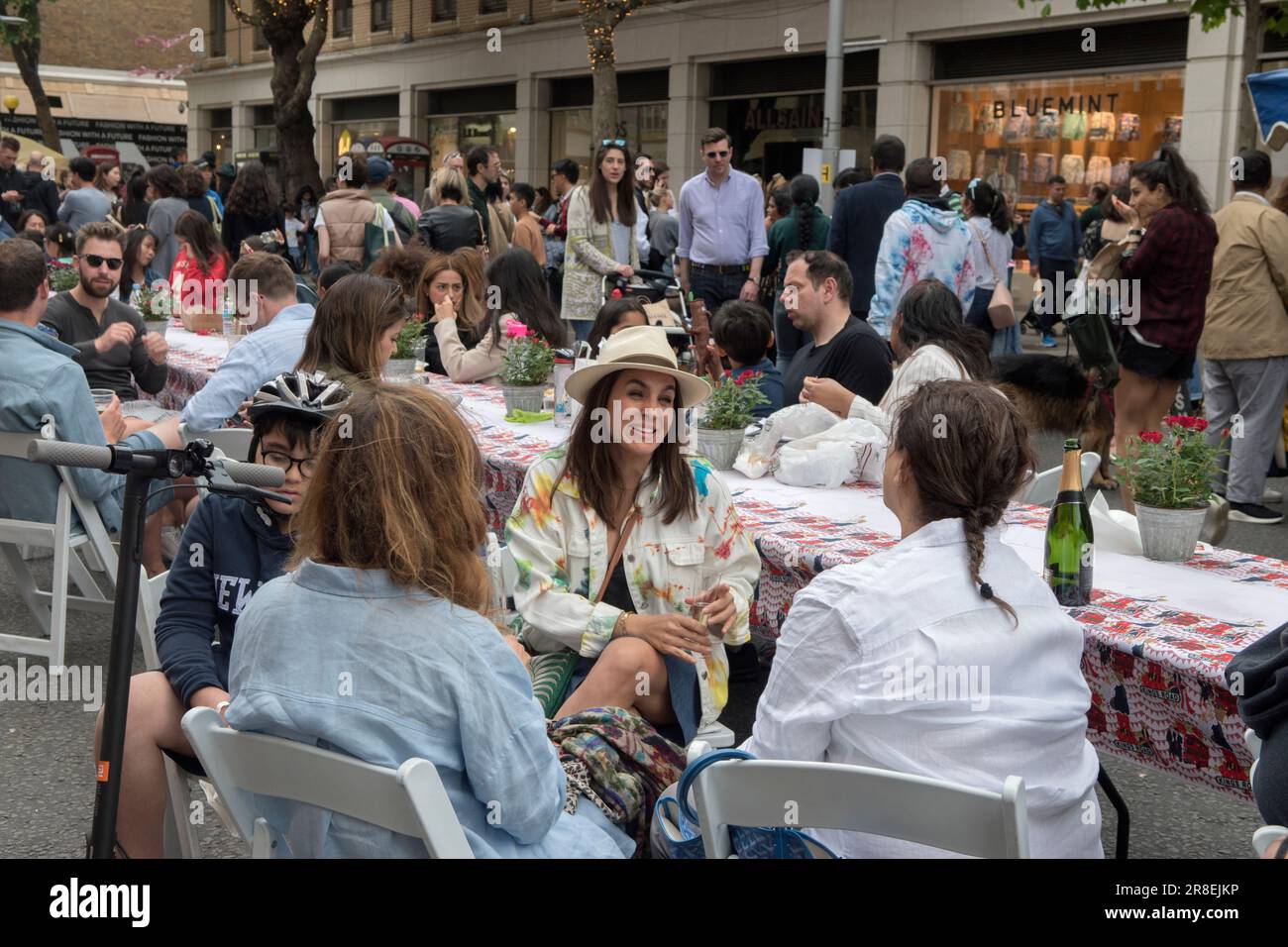 Chelsea, London, England 4th June 2022. The Kings Road, Platinum Jubilee Street Party, that is supporting the British Red Cross Ukraine crisis appeal. The Kings Road is in part closed to traffic, tables run down the centre of the road, local Chelsea and Knightsbridge young adults, chat and drink Champagne. Stock Photo