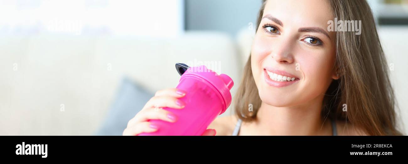 Smiling Intake Portrait of sporty smiling beautiful woman with bottle of water. Sports ...