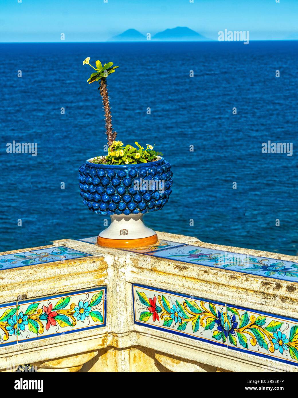 Carved handrail with ceramic pattern and surmounted by a blue basin with a cactus in the city Santo Stefano di Camastra Stock Photo