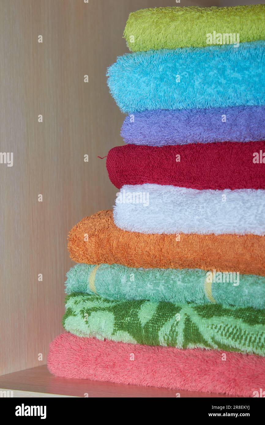 a set of towels are arranged in a closet on a shelf Stock Photo