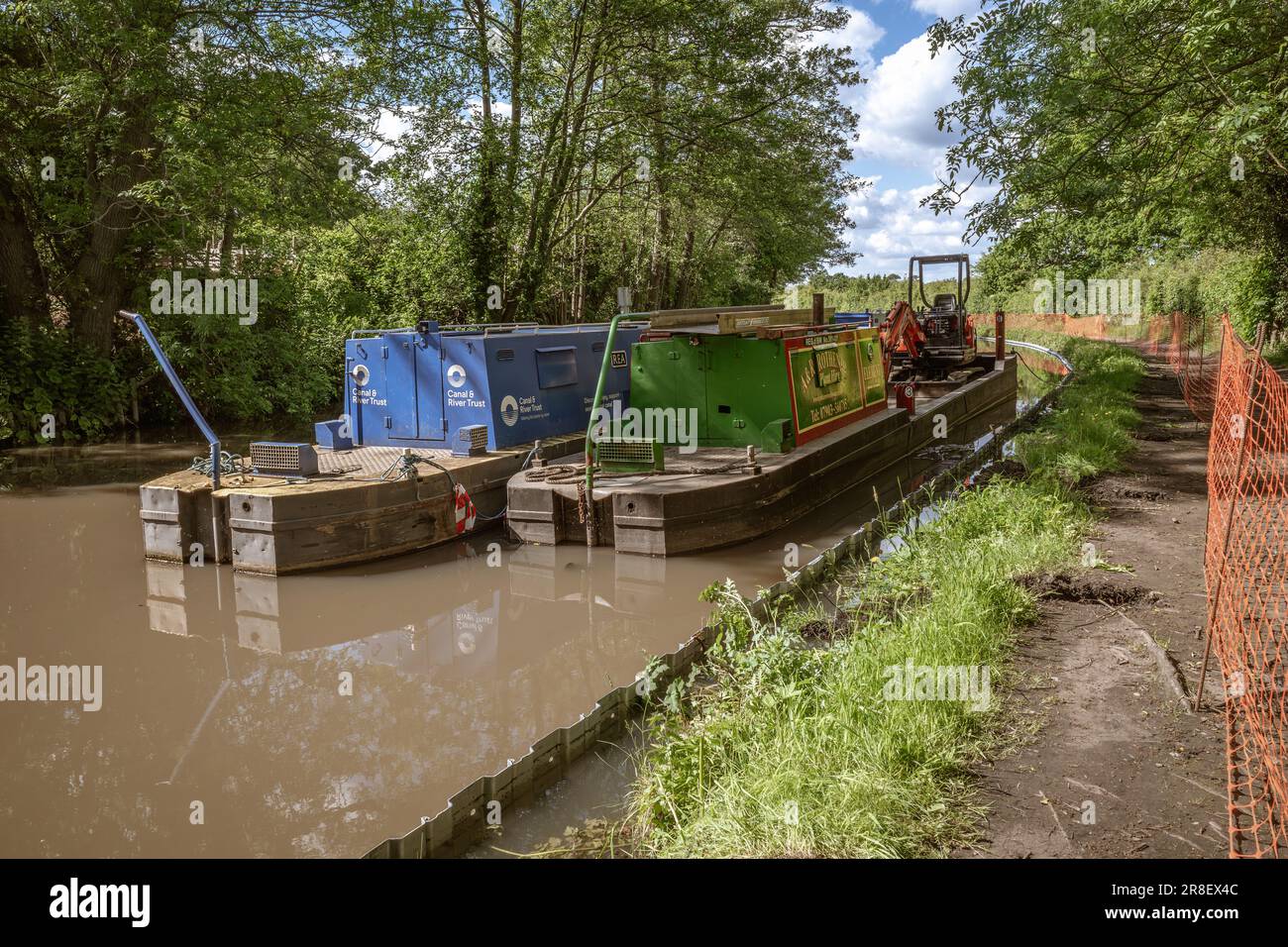 Workboats on a canal in Worcestershire, one carrying an excavator prepare to carry out essential works along the waterway. Canal & River Trust. Stock Photo