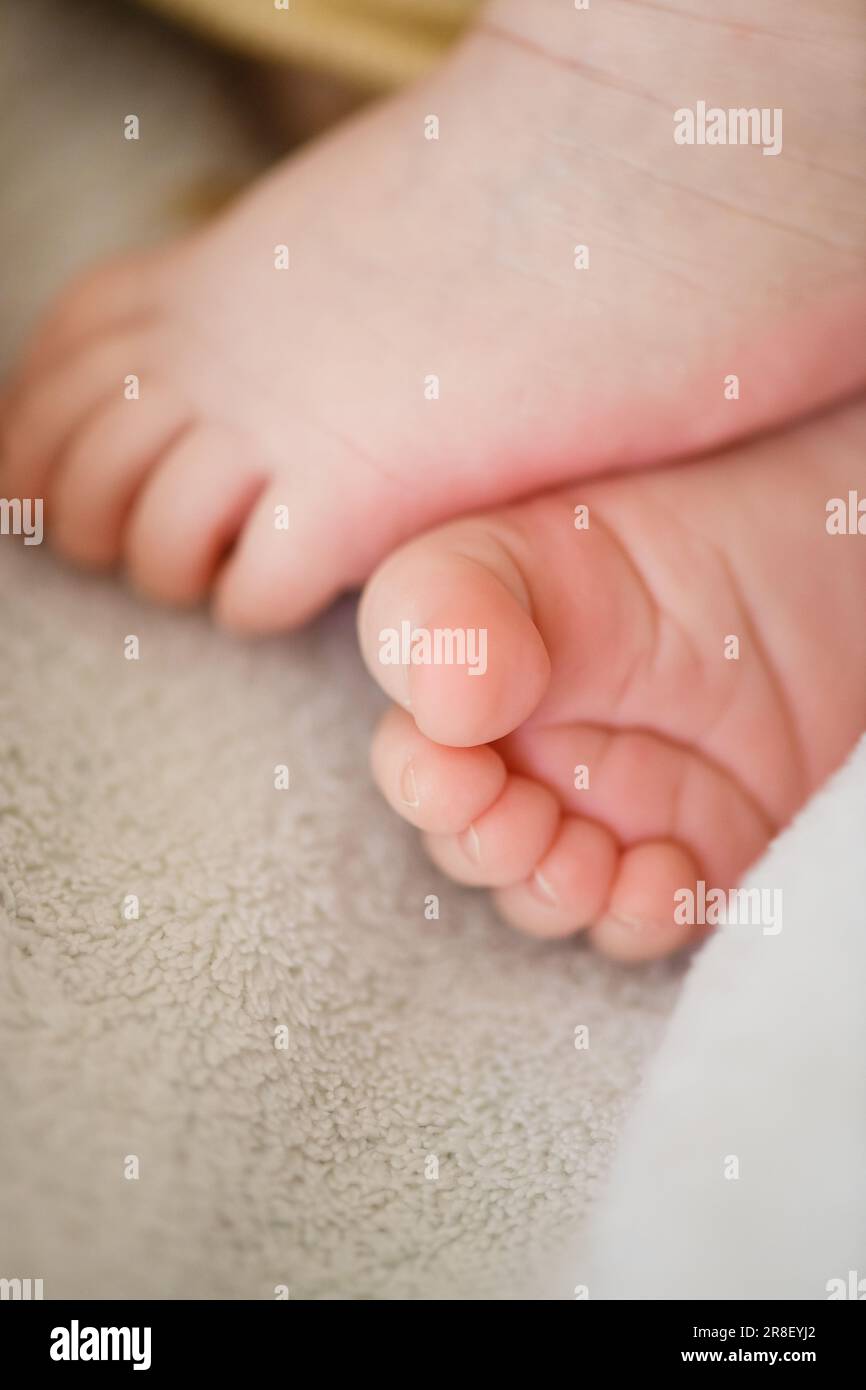 Sweet tiny baby newborn feet toes close up macro, relaxed in bed crib