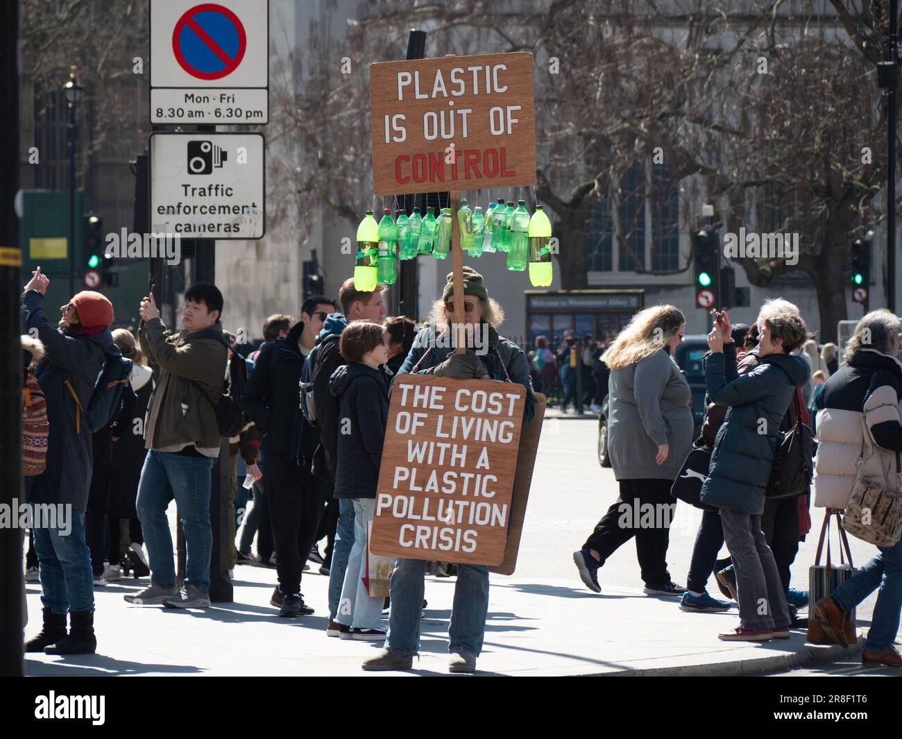 Plastic pollution protestor, demonstrator, outside The houses of Parliament with sandwich board stating 'Plastic is out of control' Stock Photo