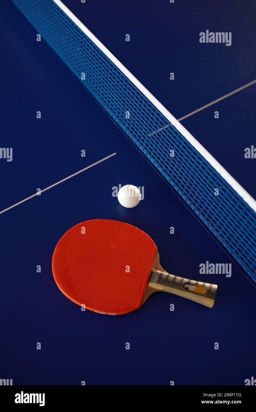 Table tennis equipment on blue ping pong table with grid net Stock