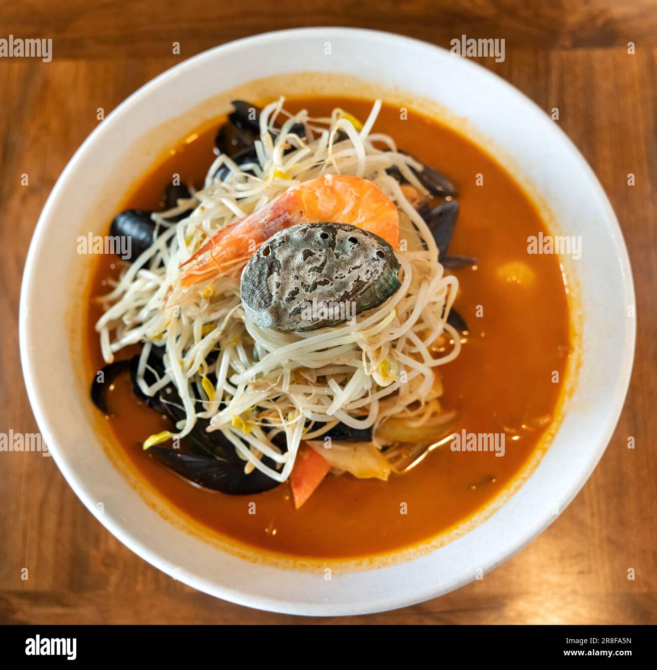 Delicious jjamppong, jjambbong, Chinese-style Korean noodle soup topped with red, spicy seafood and kimchi broth in South Korea. Stock Photo