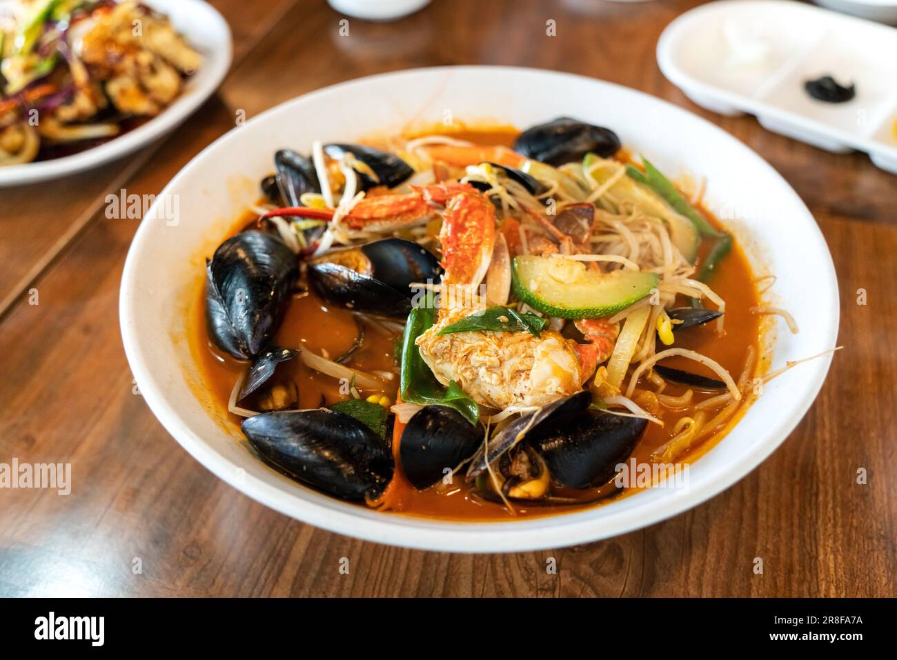 Delicious jjamppong, jjambbong, Chinese-style Korean noodle soup topped with red, spicy seafood and kimchi broth in South Korea. Stock Photo
