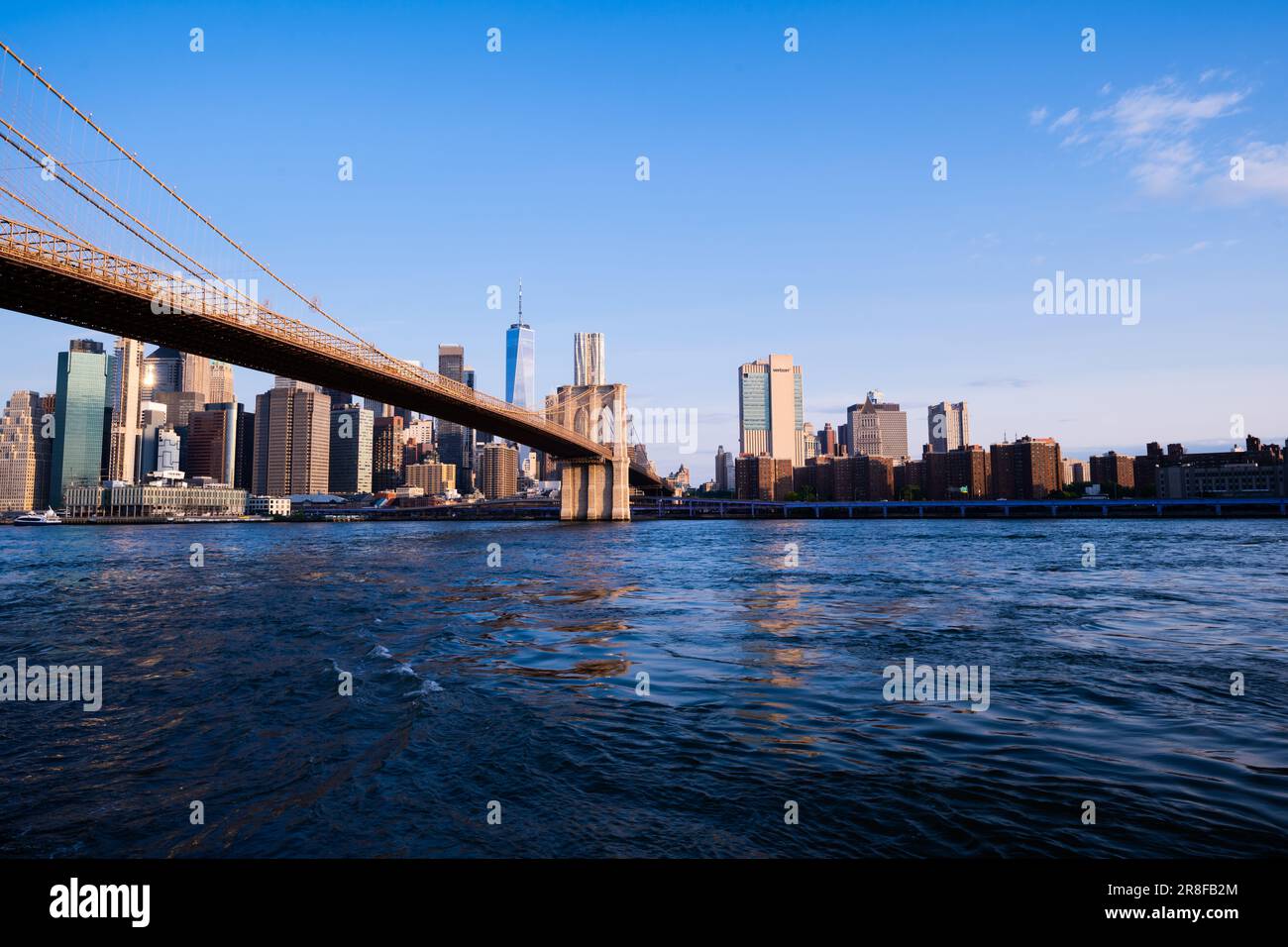 A scenic view from the bank of a river to the Manhattan Bridge. Stock Photo