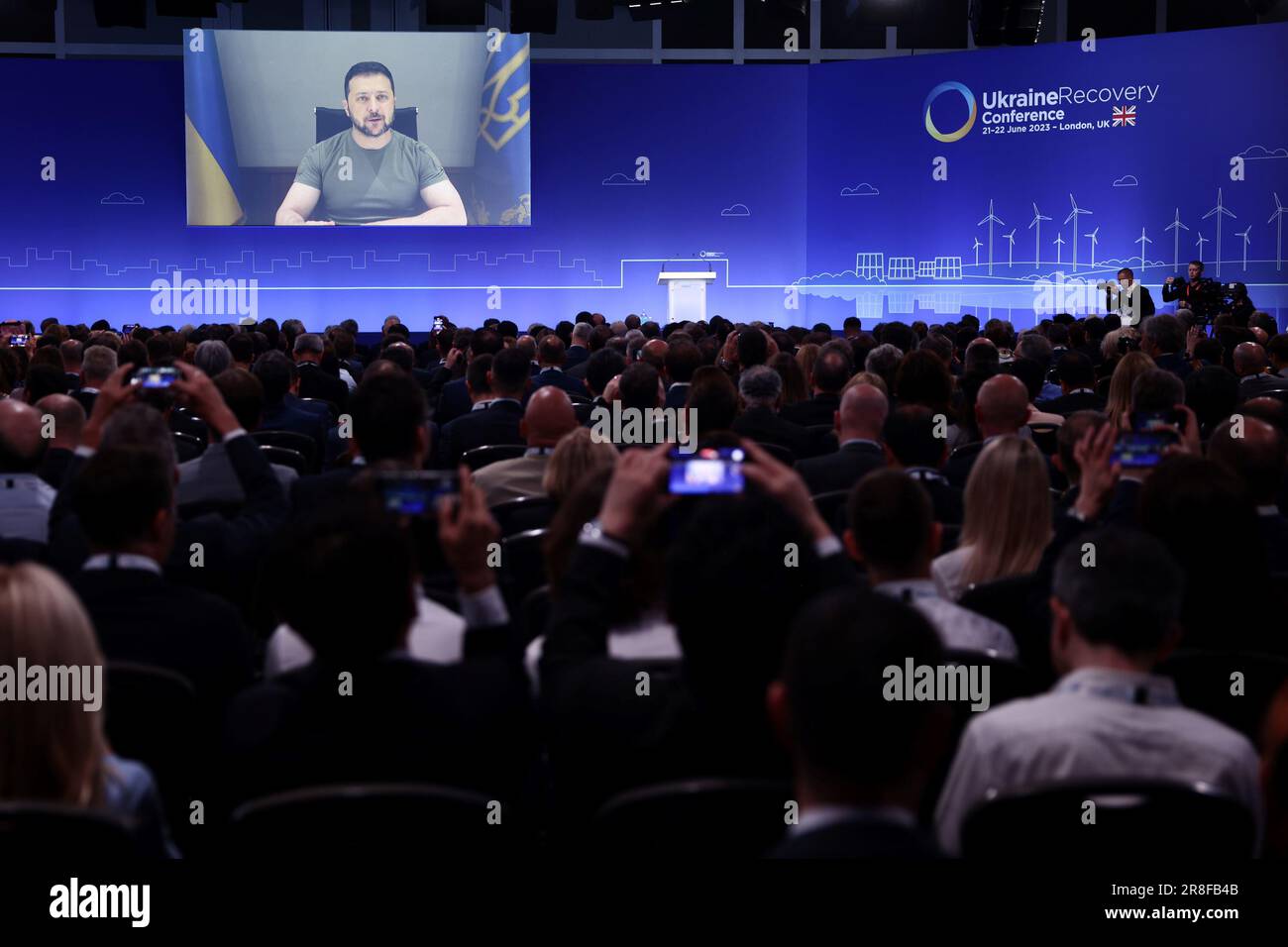 Ukraine's President Volodymyr Zelensky delivers a speech via videolink at the opening session on the first day of the Ukraine Recovery Conference, held at the InterContinental London - O2, in east London. Picture date: Wednesday June 21, 2023. Stock Photo