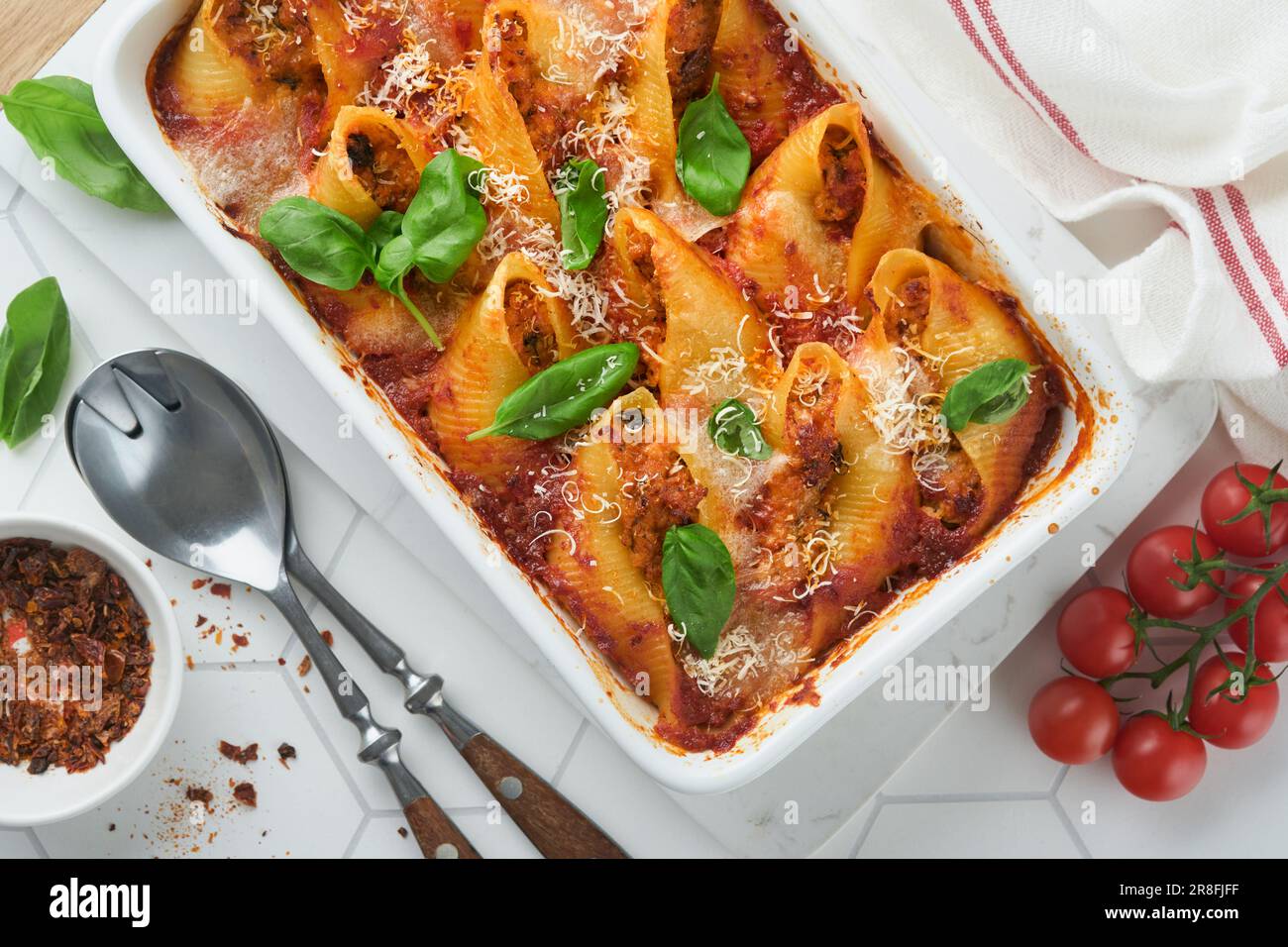 Cannelloni or conchiglioni. Baked white tile shells Photo basil Alamy tomatoes, Traditional pasta modern stuffed Stock table. with - bolognese bolo sauce, meat on Italian