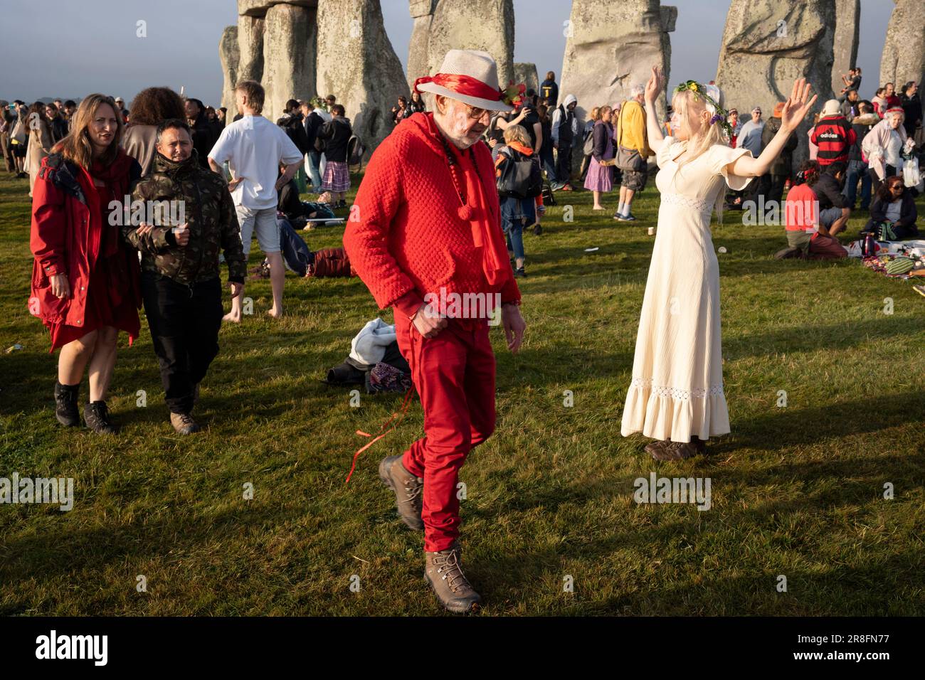 Spiritually-minded revellers celebrate the summer Solstice (mid-summer and longest day) at the ancient late-Neolithic stones of Stonehenge, on 21st June 2023, in Wiltshire, England. The summer solstice is the northern hemisphere's longest day and shortest night of the year, when the earth’s axis is tilted at its closest point from the sun and pagans say the ancient monument is a sacred place that links the Earth, Moon, Sun and the seasons. Stonehenge was built in three phases between 3,000 B.C. and 1,600 B.C. Stonehenge is owned by English Heritage who say 8,000 visitors were allowed into the Stock Photo