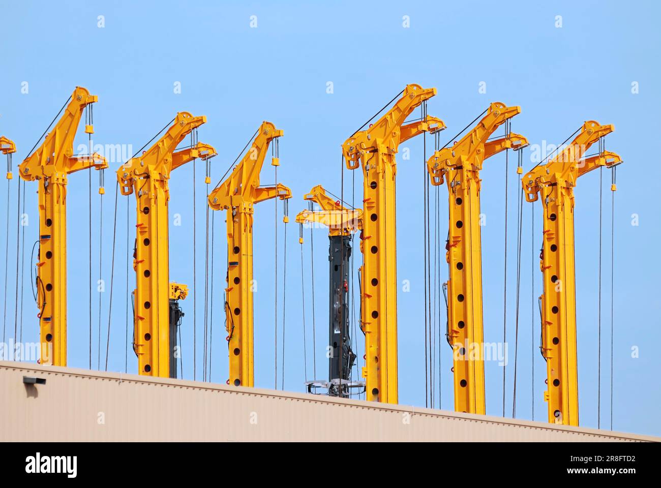 Row of yellow drilling rigs Stock Photo - Alamy