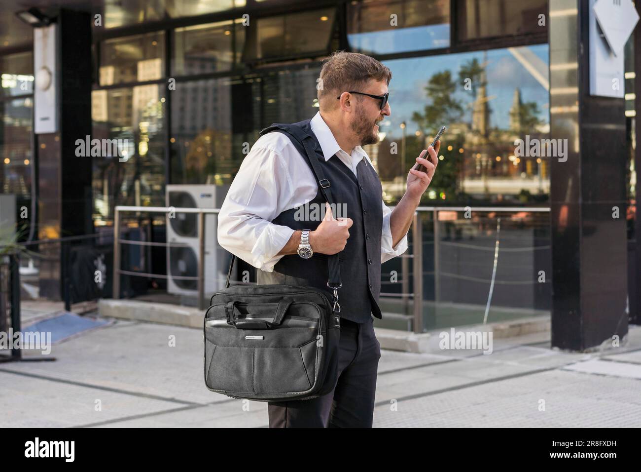 A businessman leaving a message to his friend before entering an after ...