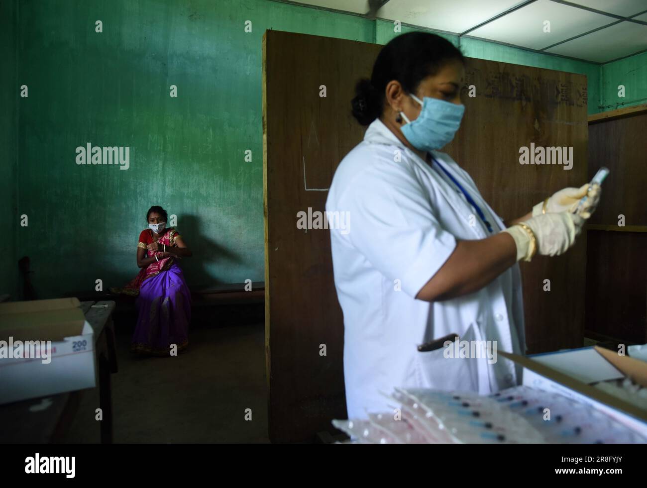 Health worker administers a COVID-19 coronavirus vaccine during a vaccination drive in Guwahati, India on Monday, June 21, 2021 Stock Photo