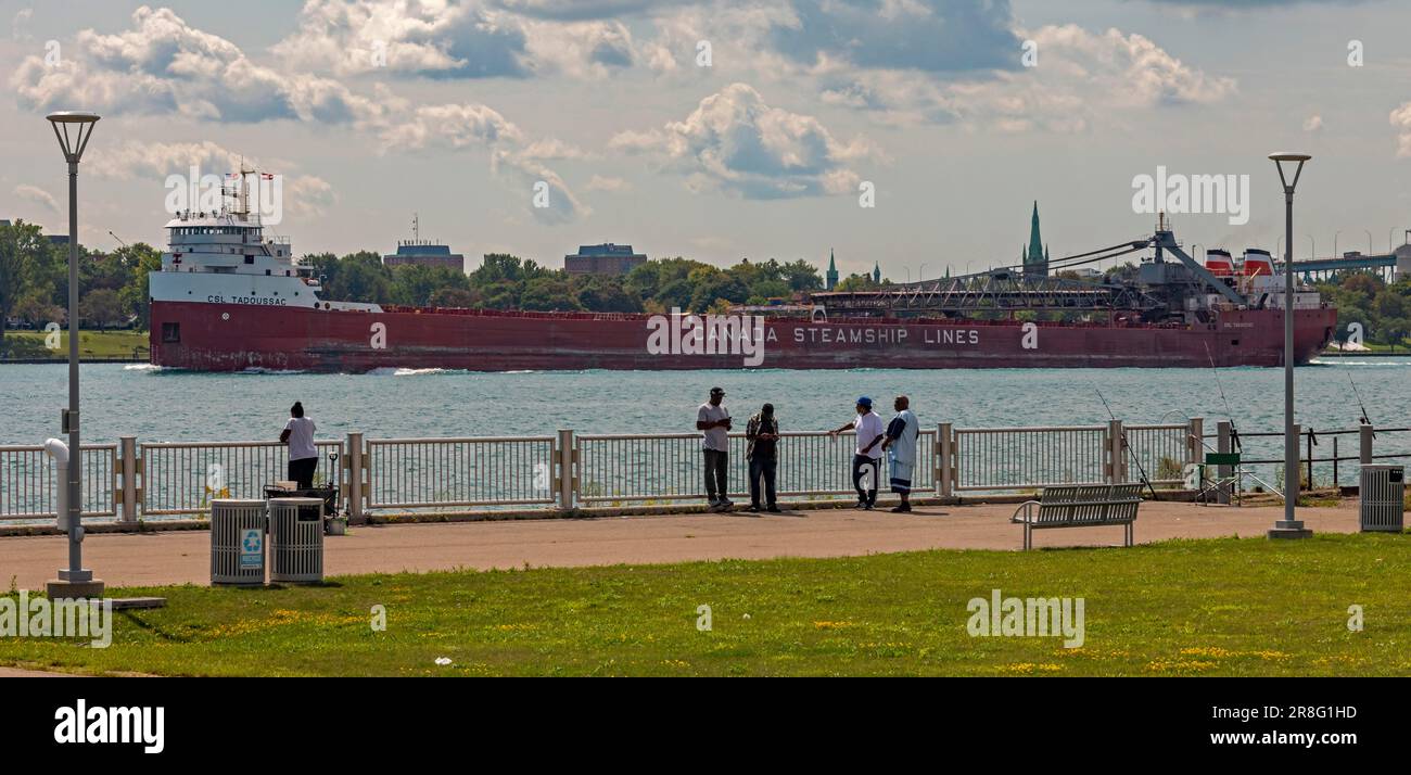 Detroit, Michigan, The CSL Tadoussac, a self-unloading bulk carrier operated by Canada Steamship Lines, sails upbound on the Detroit River, past men Stock Photo