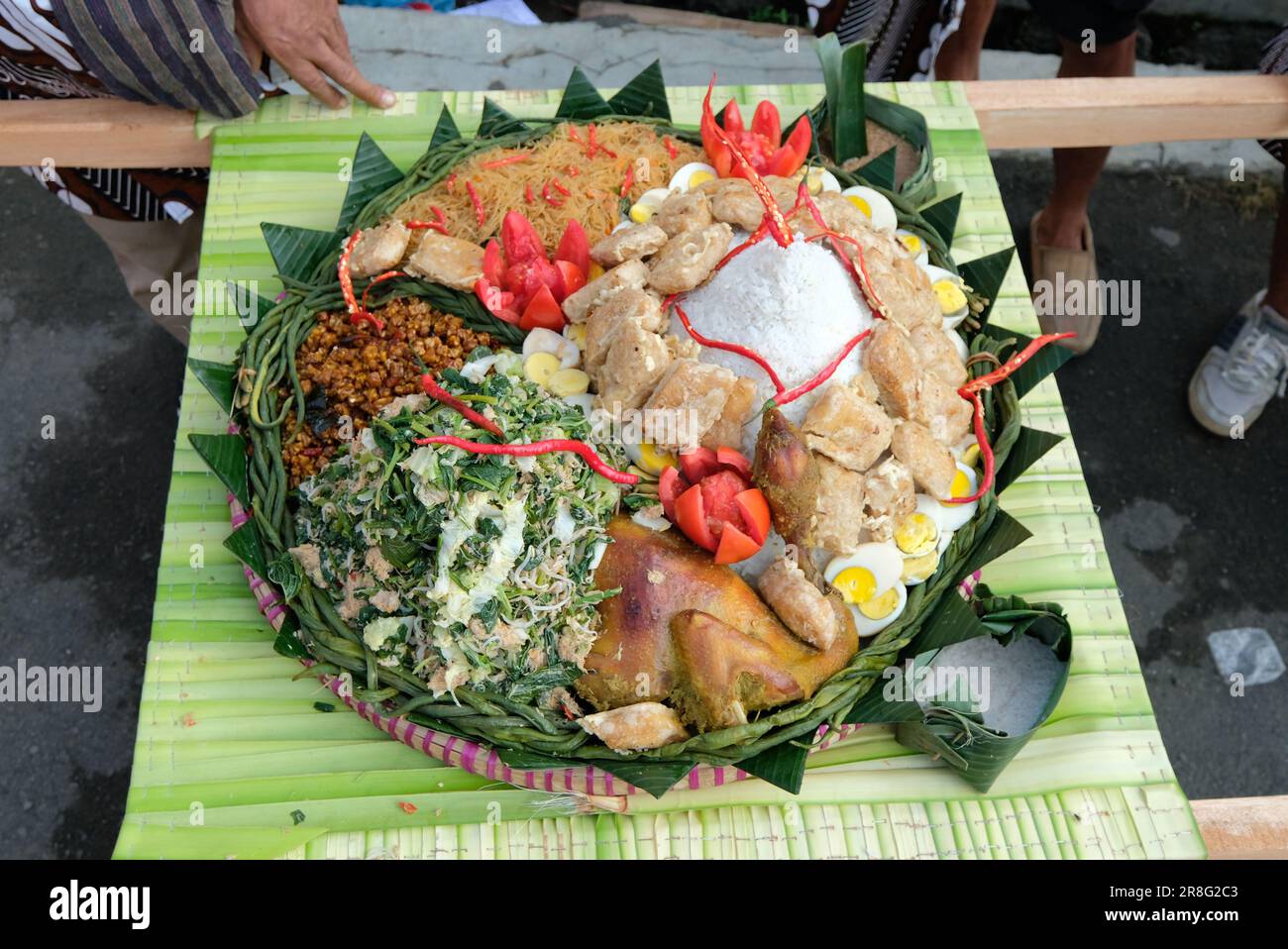 Nasi tumpeng (cone rice) served with urap-urap (Indonesian salad), fried chicken, and noodles Nasi tumpeng is usually served at birthday parties or Th Stock Photo