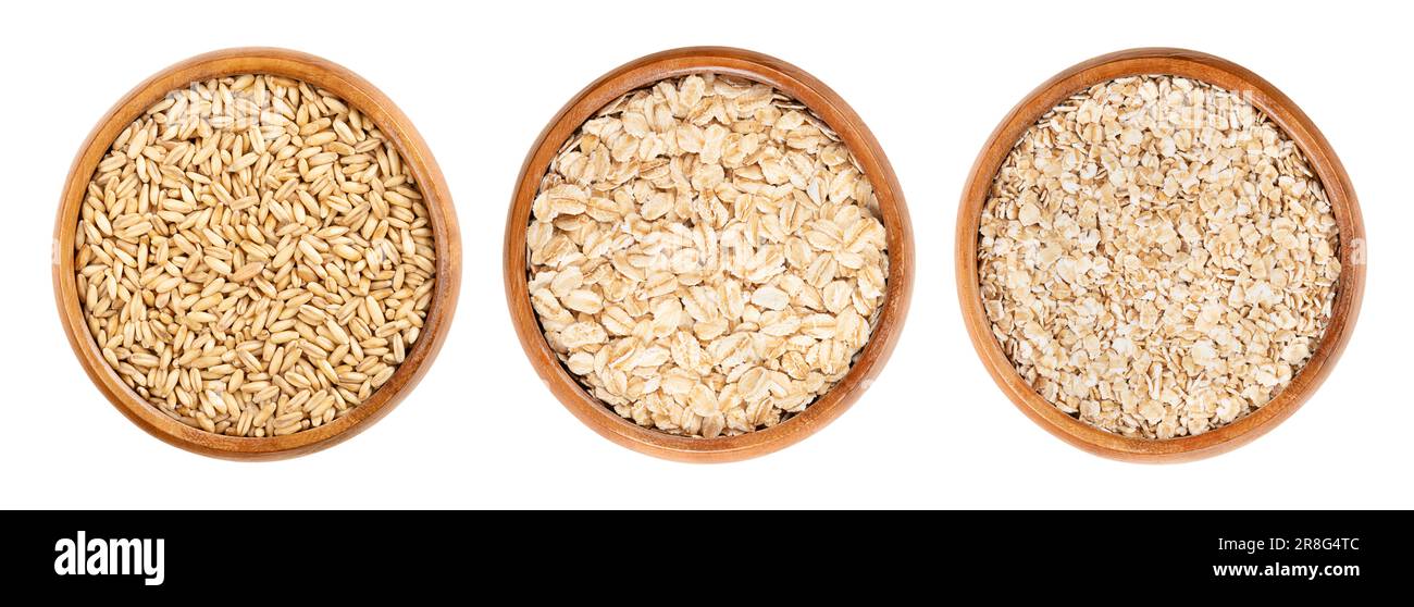 Oat grains, rolled oats and oatmeal, in wooden bowls. Husked common oat, Avena sativa, a cereal grain. Dehusked steamed oat groats. Stock Photo