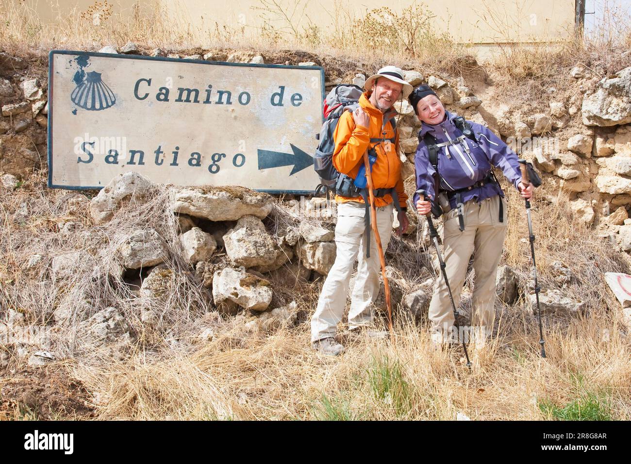 Zwei sympathische Pilger posieren vor einem Wegweiser (MR fuer editoriale Zwecke vorhanden) (nicht fuer Werbung), Castrojeriz, Provinz Burgos Stock Photo
