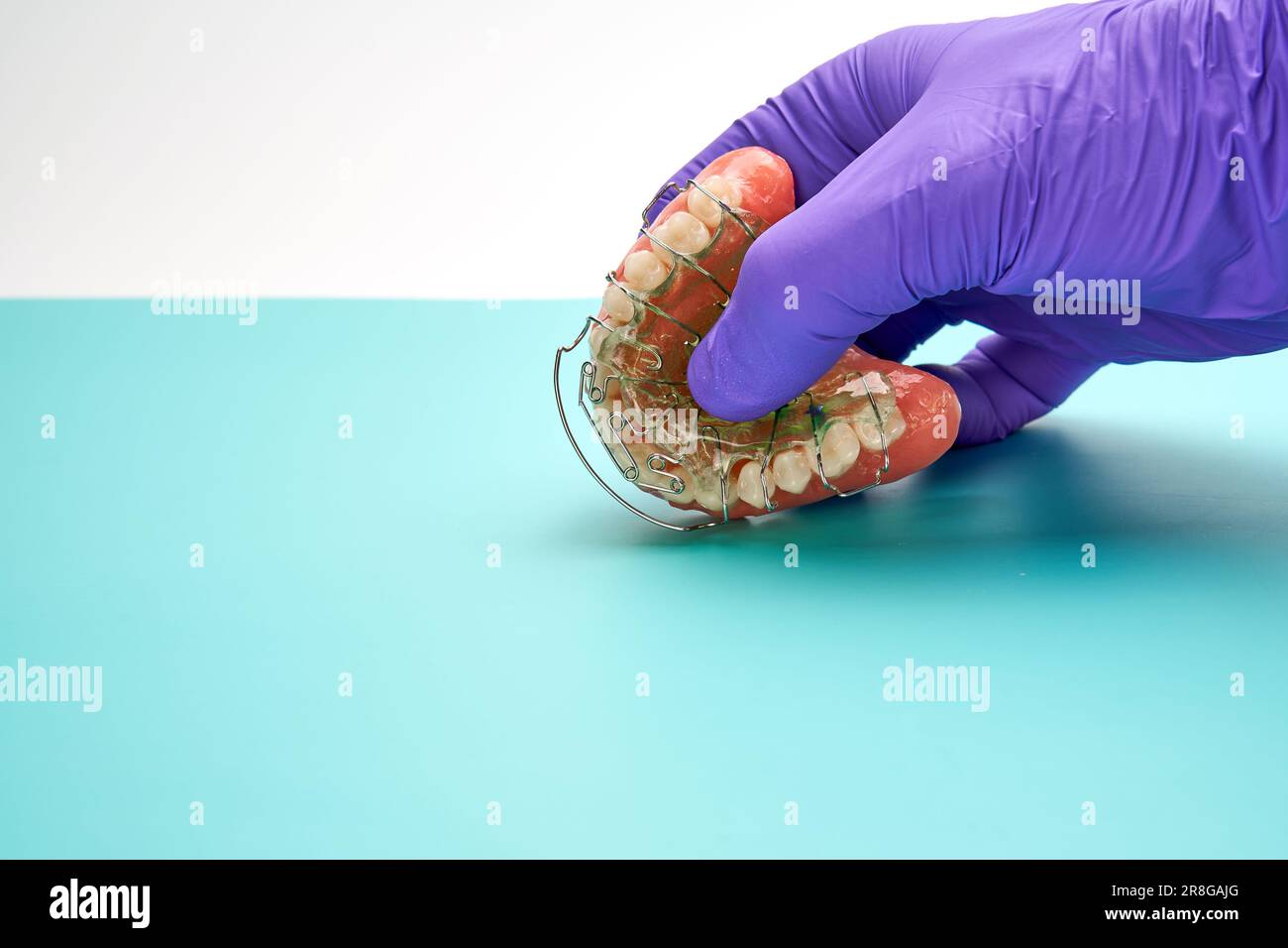 Dental technician with a denture and an orthodontic appliance in the