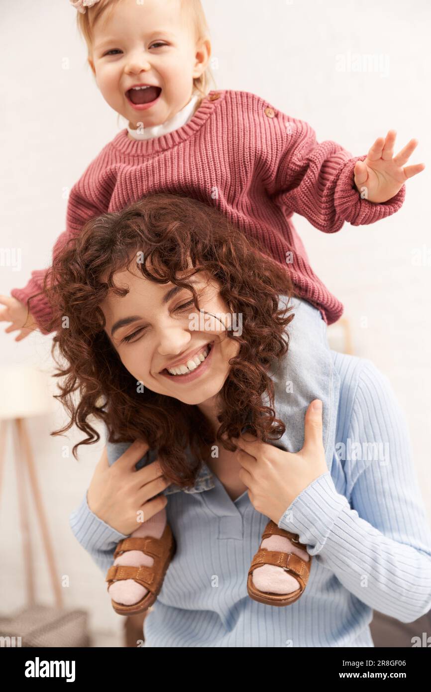 joyful woman with happy baby girl on shoulders, balanced lifestyle, mom daughter time, having fun together, quality time, work and life harmony, lovin Stock Photo