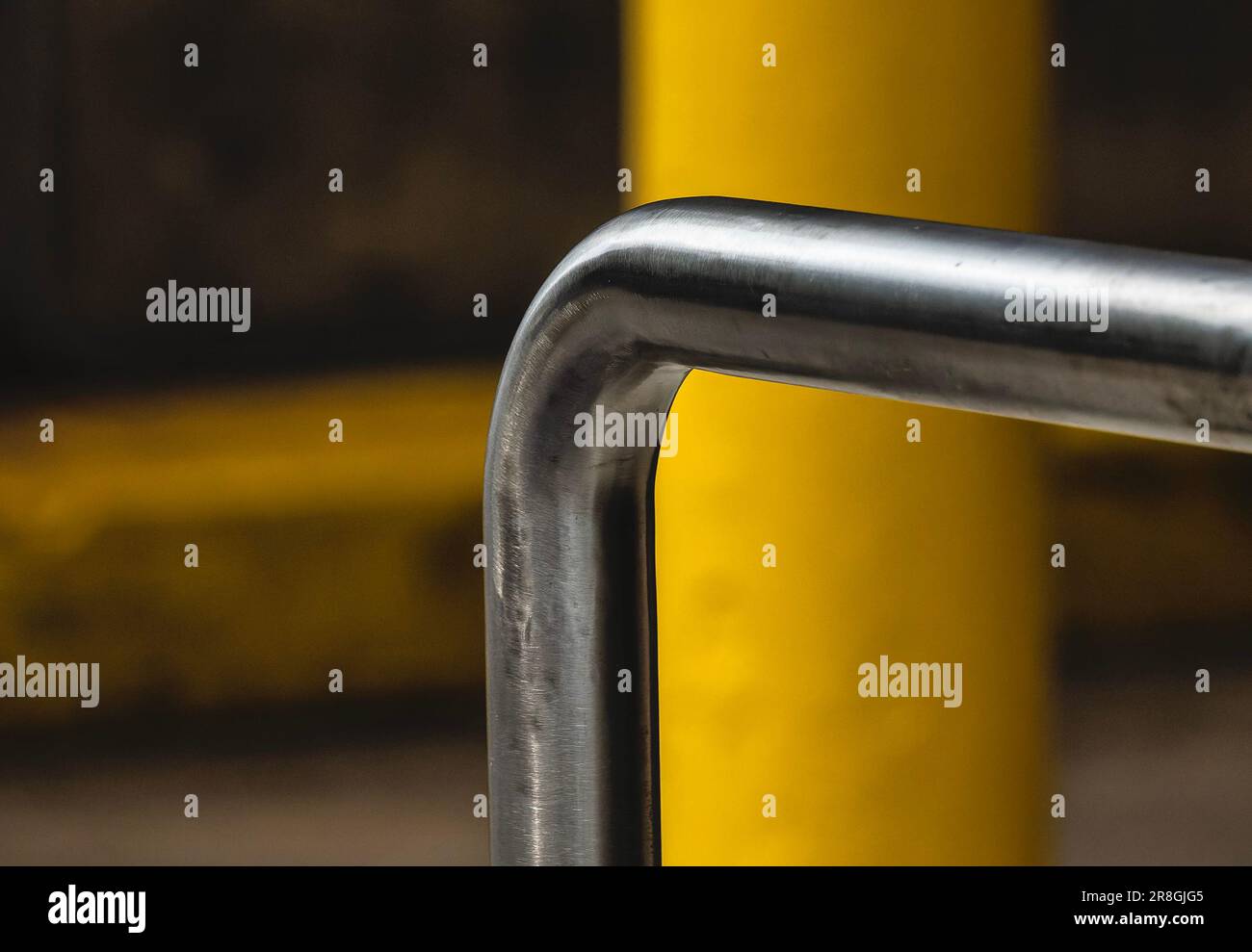 Bent metal bar in front of a yellow pipe Stock Photo Alamy