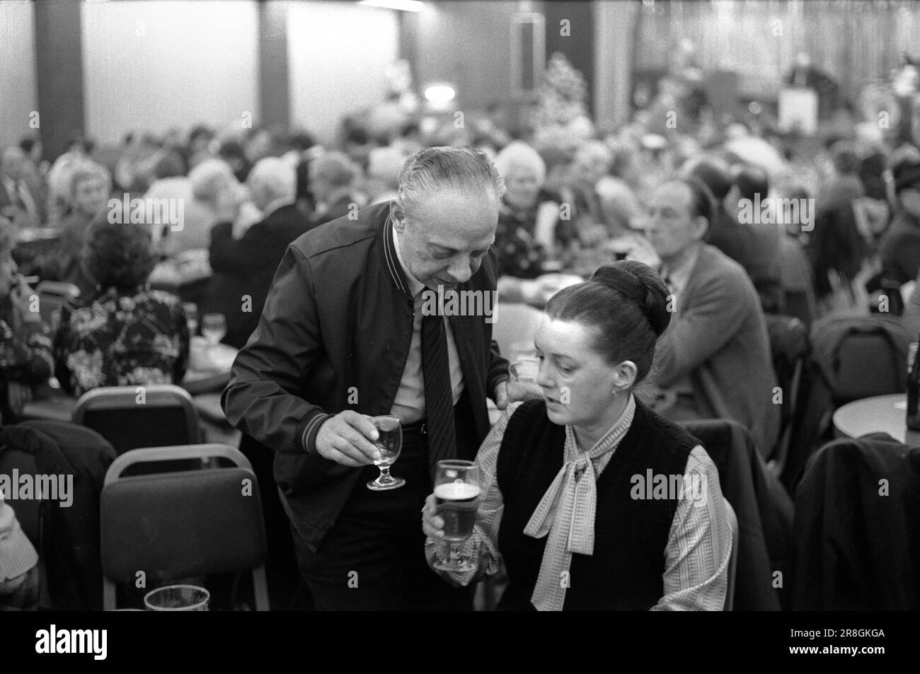 Couple 1980s Saturday night out together. Coventry Working Mens Club, Saturday night  bingo evening entertainment. Do you fancy another one 'duck'? A common expression, a term of endearment in the Midlands and the North of England. Coventry, England circa 1981 80s UK HOMER SYKES Stock Photo