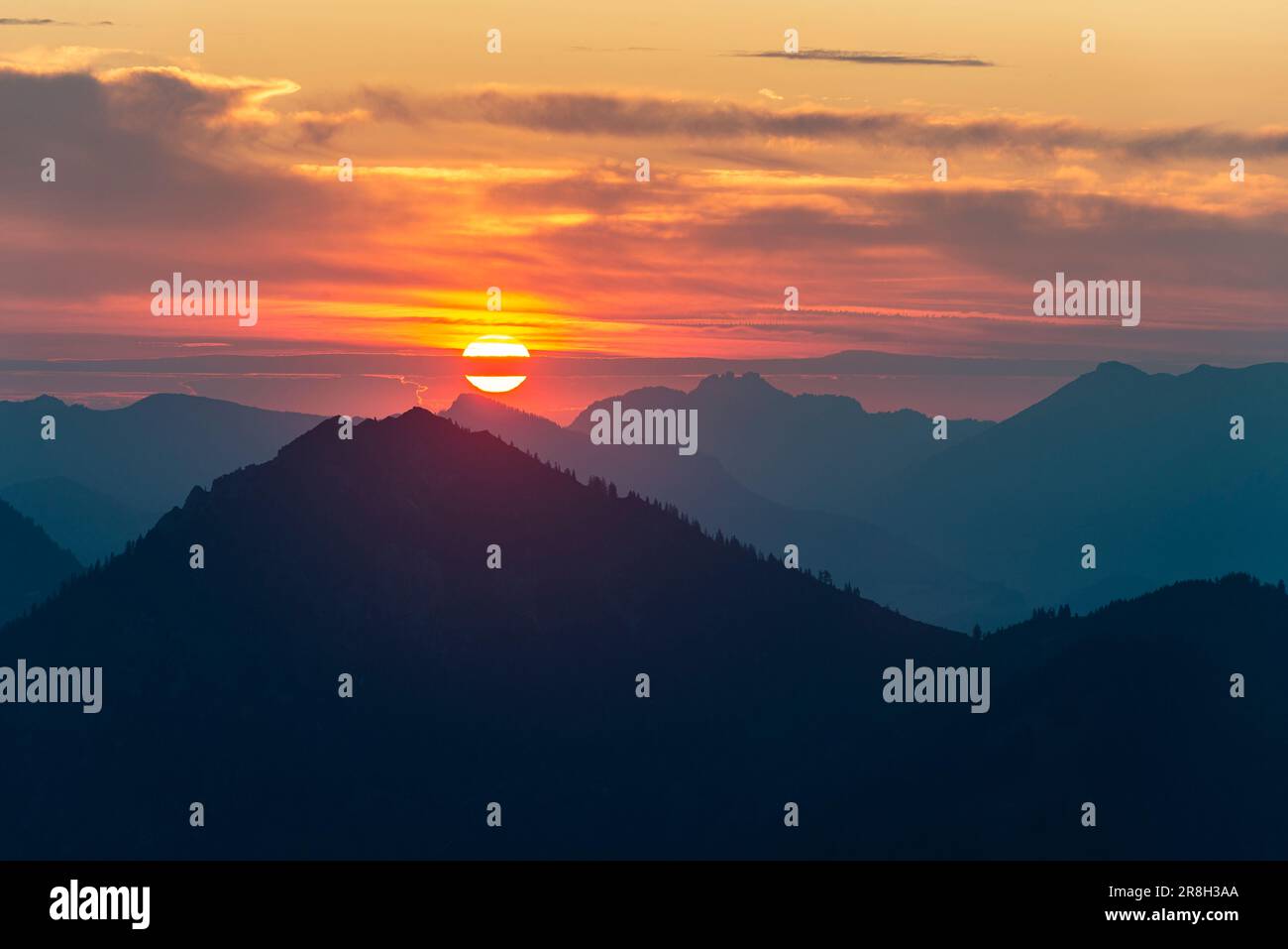 Colourful sunrise behind the Kampenwand in the Chiemsee Mountains in the Bavarian Alps, Tyrol, Austria Stock Photo