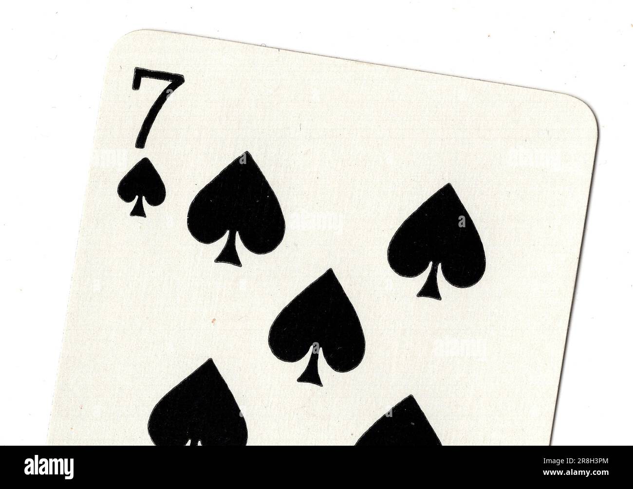 A seven of spades vintage playing card on a white background Stock