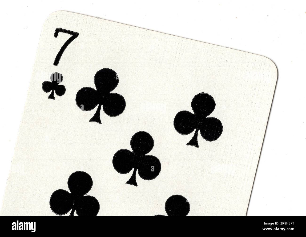 A seven of clubs vintage playing card on a white background. Stock Photo