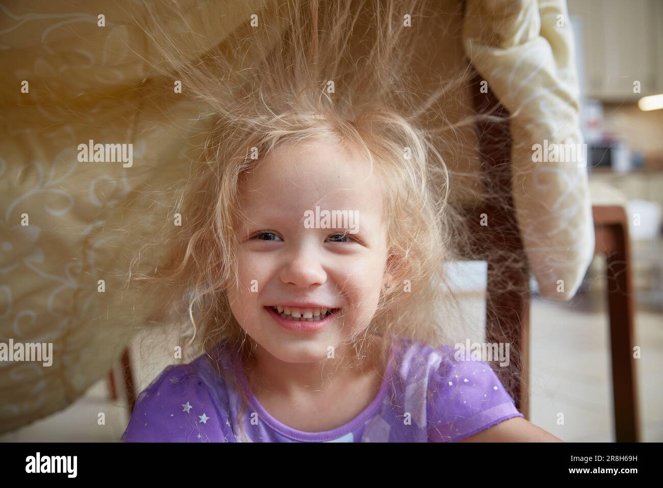 Static electricity electrified the hair of a little girl sitting under