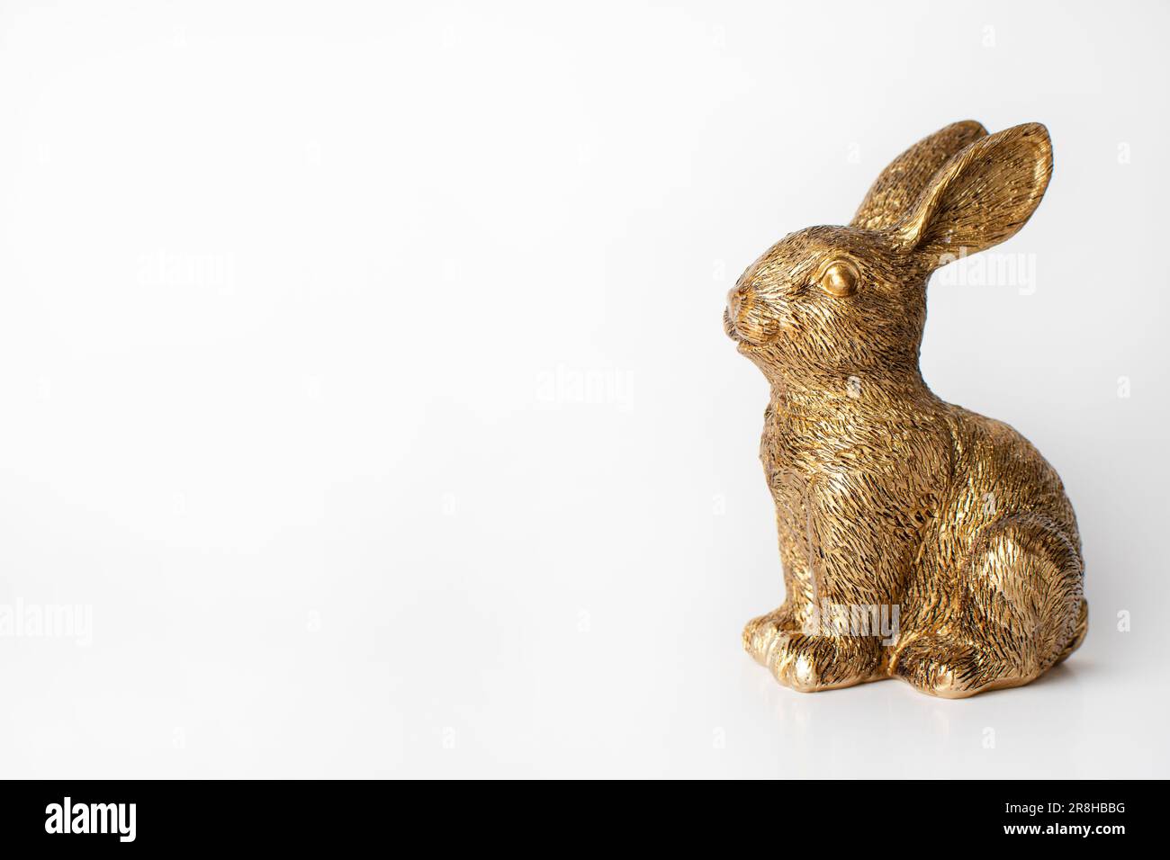 Golden rabbit figurine on the white background. Free space Stock Photo