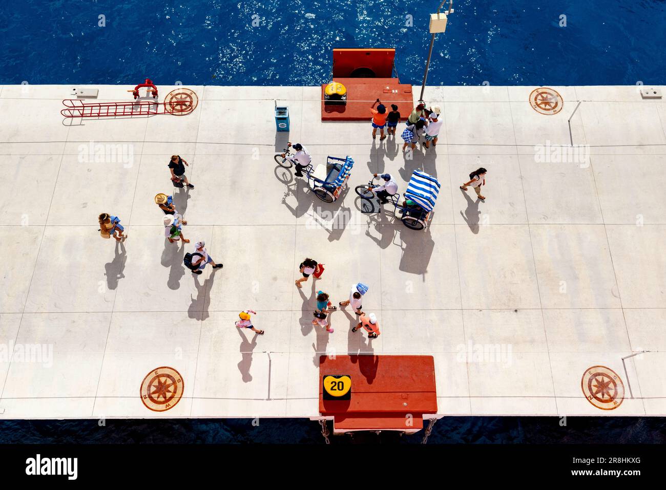 Overhead view of people walking and bicycle taxis at the cruise terminal in Cozumel, Mexico Stock Photo