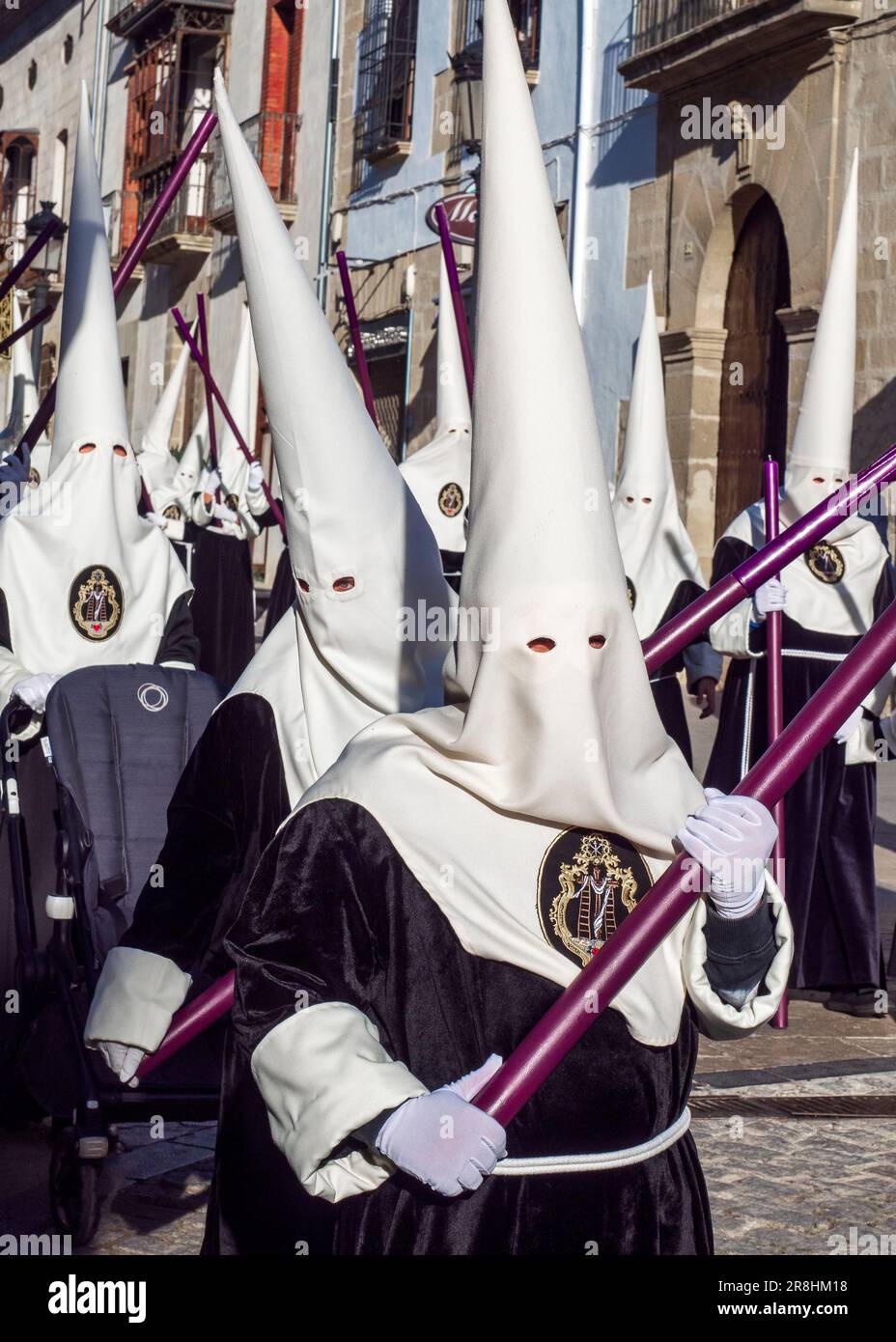 Nazarenes with tunic and hood in the processions in the streets of Baeza during the celebration of its traditional Holy Week. Stock Photo
