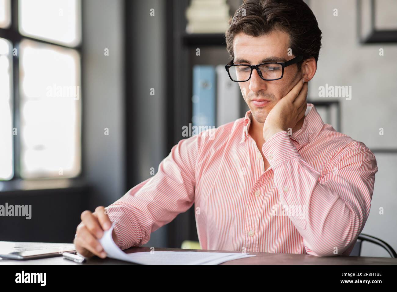 Busy corporate young man working with papers at office Stock Photo