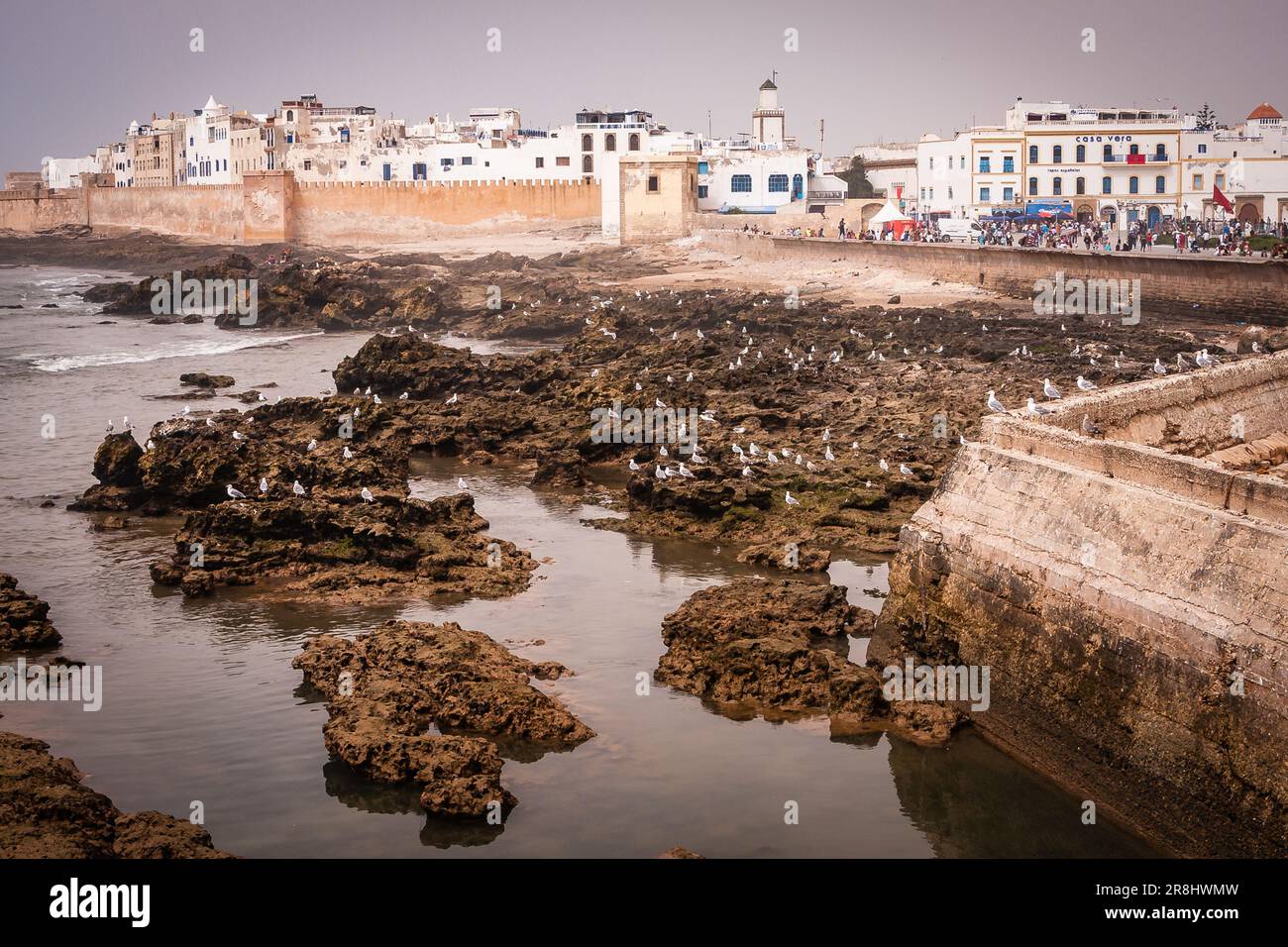 Fortification walls, with the rocks of the sea, on an evening at sunset. Essaouira, known until the 1960s as Mogador, is a port city in the western Mo Stock Photo