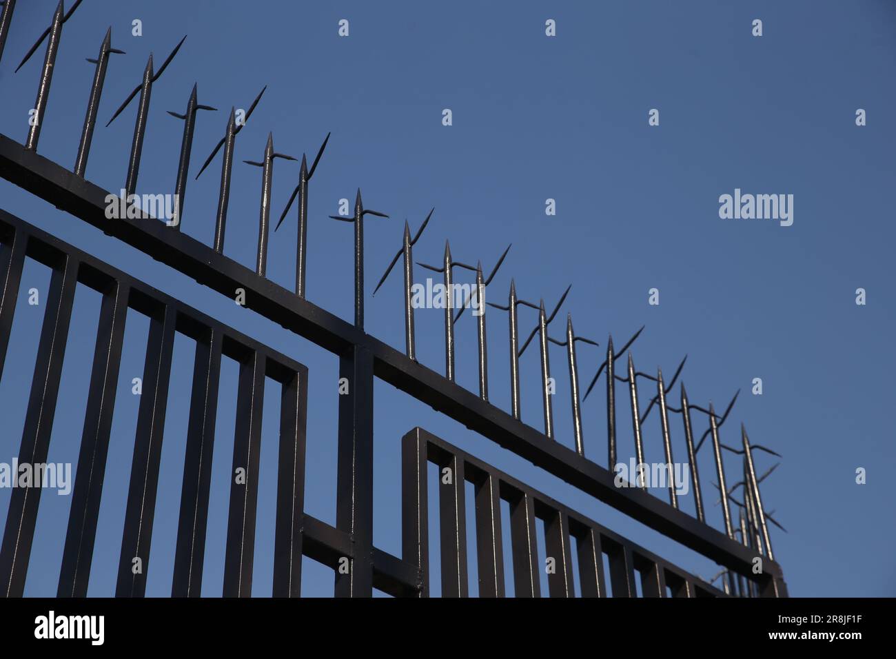 Spiky metal barrier and clear sky, low angle view image Stock Photo