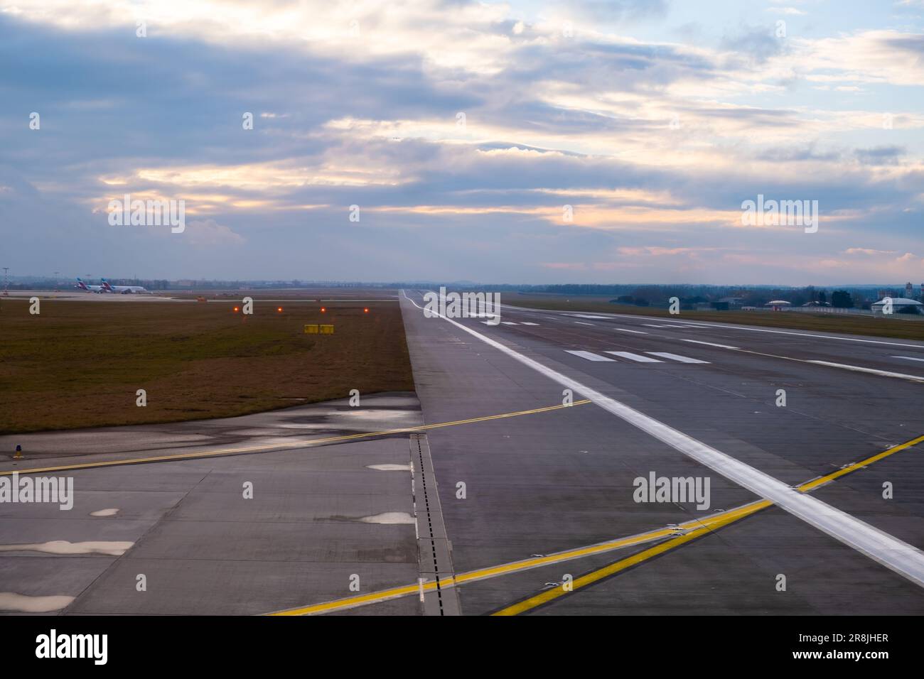 A long, straight runway stretches into the distance at the airport ...