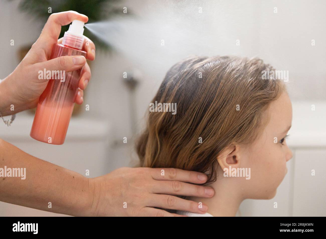 A woman helps to get rid of lice and parasites on the head of a little