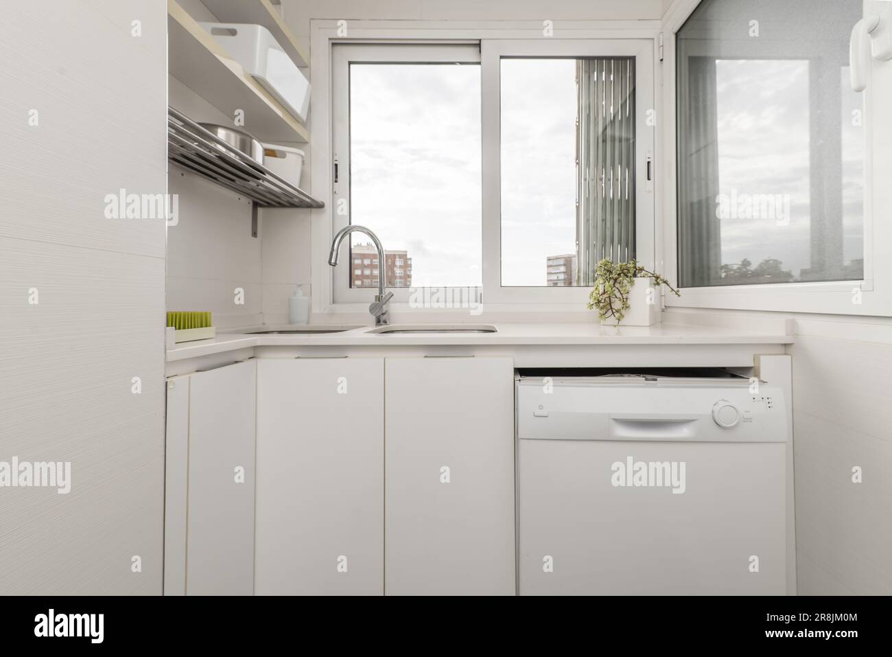 Small kitchen cubicle with dishwasher, double sink and white aluminum