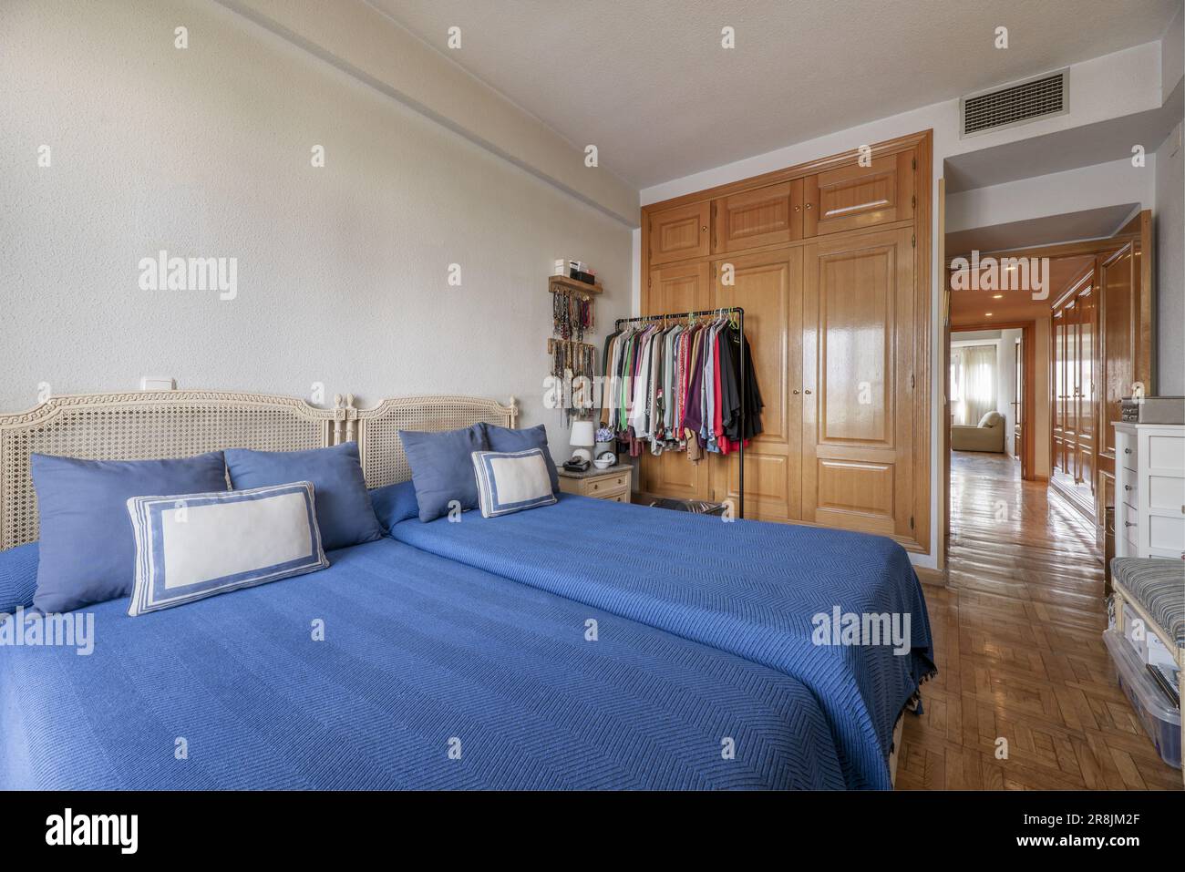 Bedroom with two single beds, blue bedspreads, twin headboards and an