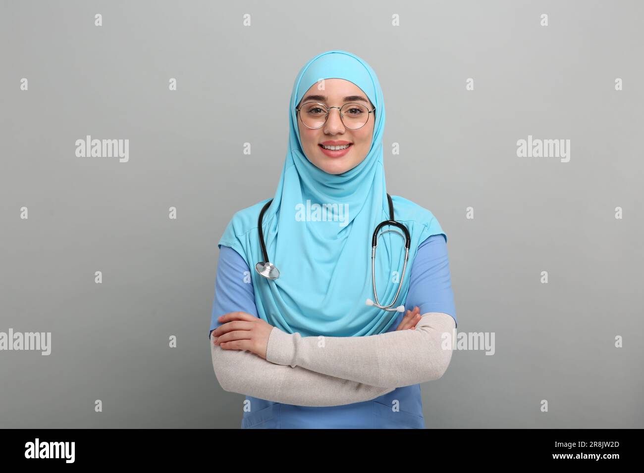 Muslim woman wearing hijab, medical uniform with stethoscope on light