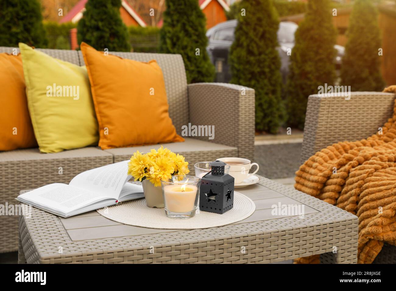 Beautiful rattan garden furniture, soft pillows and different decor elements outdoors Stock Photo