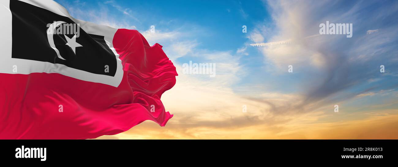 official flag of Kuala Nerus, Terengganu Malaysia at cloudy sky background on sunset, panoramic view. Malaysian travel and patriot concept. copy space Stock Photo