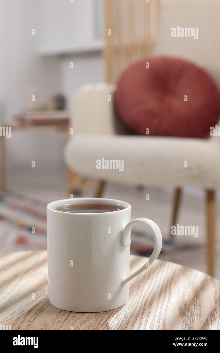 White mug of tea on wooden table indoors, space for text Stock Photo