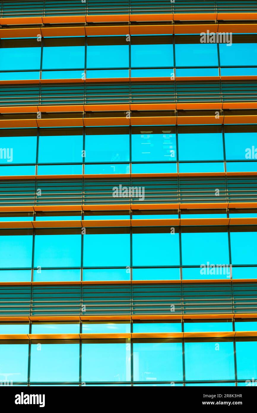 Solar reflective glass panels on the exterior of a high-rise building. The reflection of the blue sky in the glass panels offers an interesting contra Stock Photo
