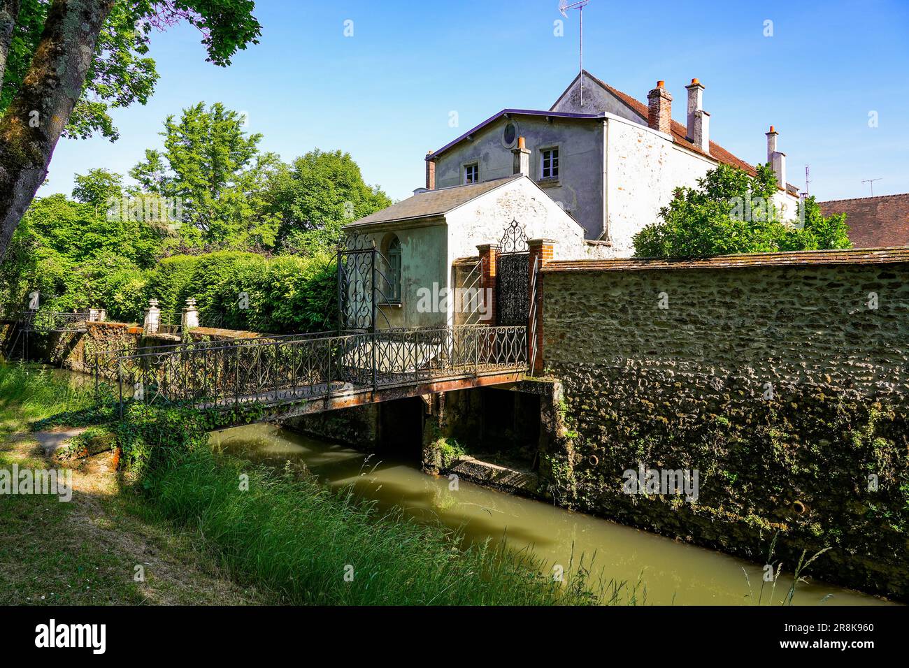 Access bridges spanning the Grand Morin river to reach some private gardens and backyards in Crécy la Chapelle, a village of Seine et Marne in Paris r Stock Photo