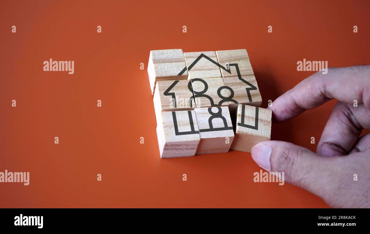 Hand arrange wooden cube with house and family icon. Settle down, family planning and home ownership concept Stock Photo