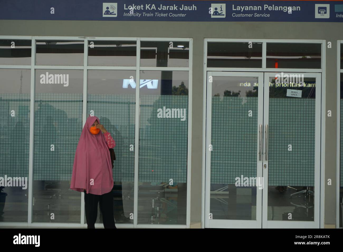 a woman wearing a hijab waiting for a train at the station Stock Photo ...