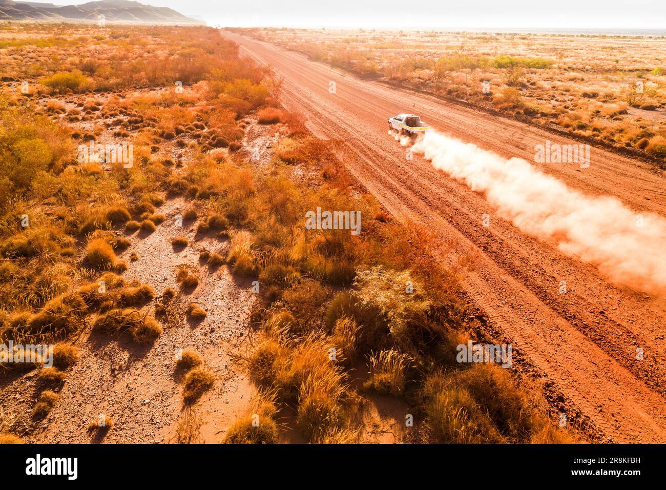 Aerial view of a motor vehicle travelling on a dirt road, Pilbara