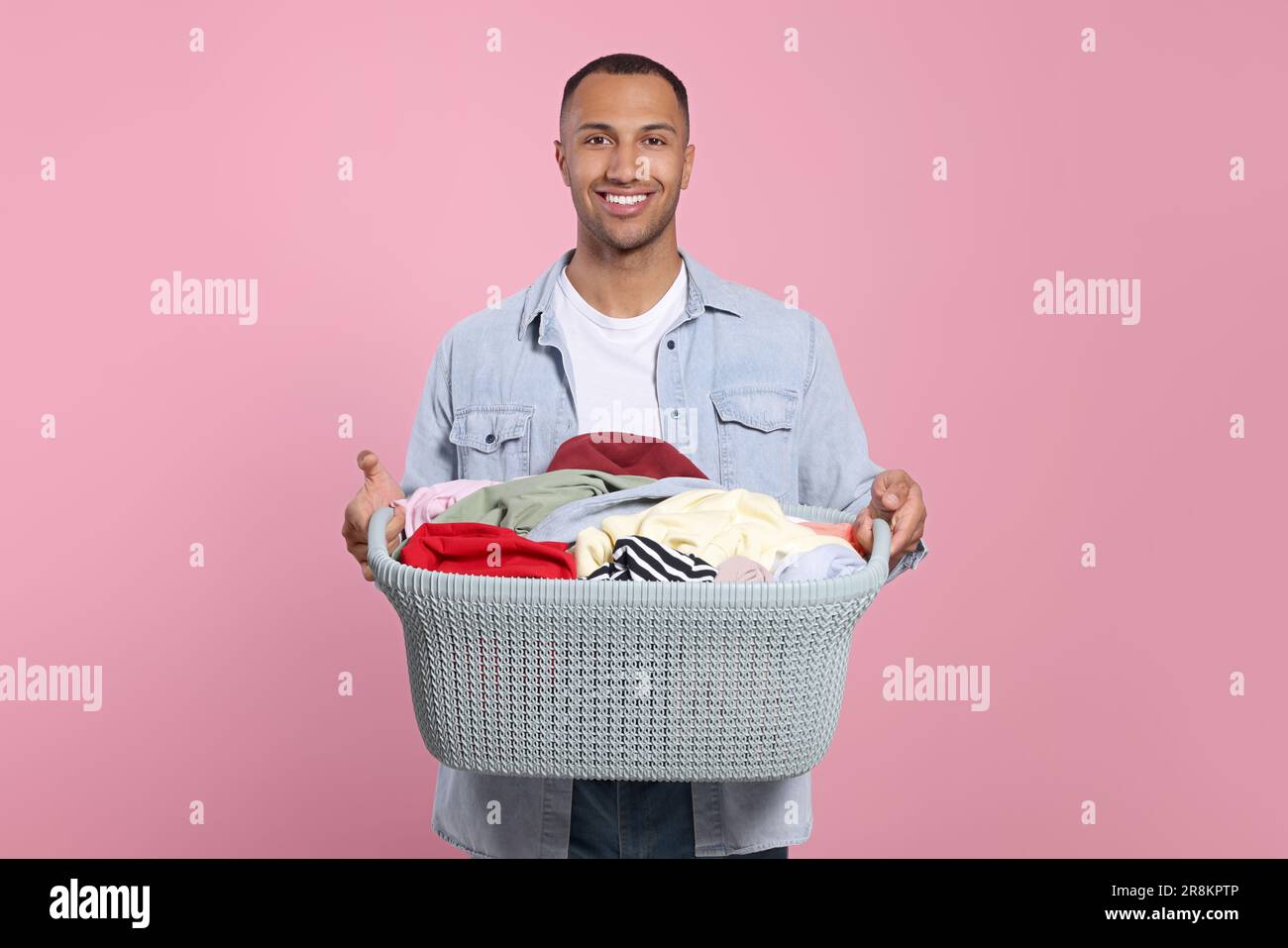 https://c8.alamy.com/comp/2R8KPTP/happy-man-with-basket-full-of-laundry-on-pink-background-2R8KPTP.jpg