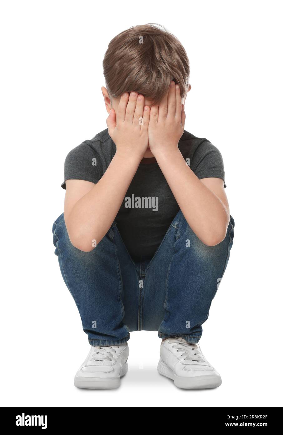 Boy covering face with hands on white background. Children's bullying Stock Photo
